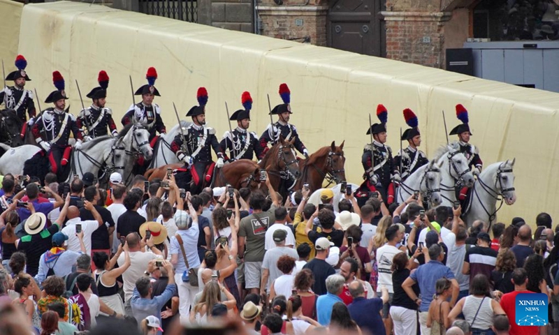 Italian Carabinieri perform before the suspension of the horse race Palio in Siena, Italy, Aug. 16, 2022. The horse race Palio has been postponed to Aug. 17 due to the rain. The historical horse race Palio is held again this year after a two-year pause because of the COVID-19 pandemic. (Xinhua/Jin Mamengni)