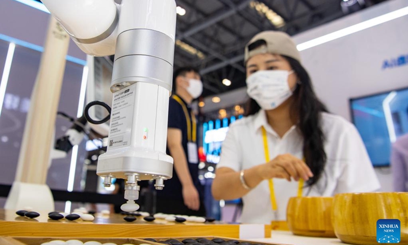 A woman plays Go, or Weiqi, with a robot during the Smart China Expo 2022 in southwest China's Chongqing, Aug. 22, 2022. The Smart China Expo 2022 opened Monday in southwest China's Chongqing Municipality, attracting over 500 exhibitors from home and abroad to showcase their latest intelligent technology achievements.(Photo: Xinhua)