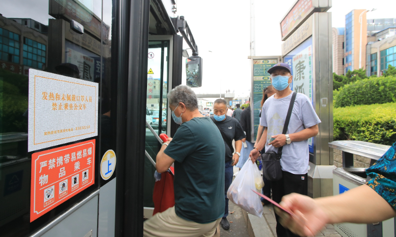 Residents get on a bus in Dalian on August 29, 2022. Photo: VCG