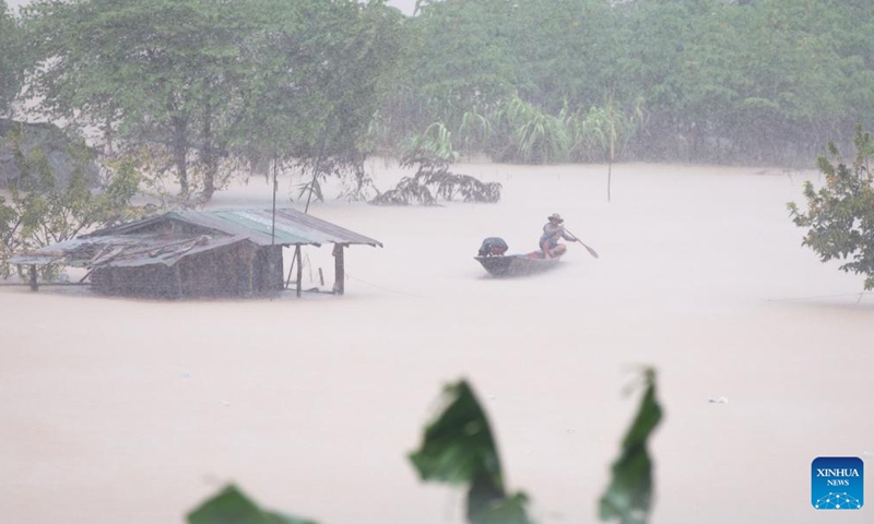 A villager rows a boat in the rain in Mekong River along submerged sandbanks, to the west of Lao capital Vientiane, on Aug. 20, 2022.Photo:Xinhua