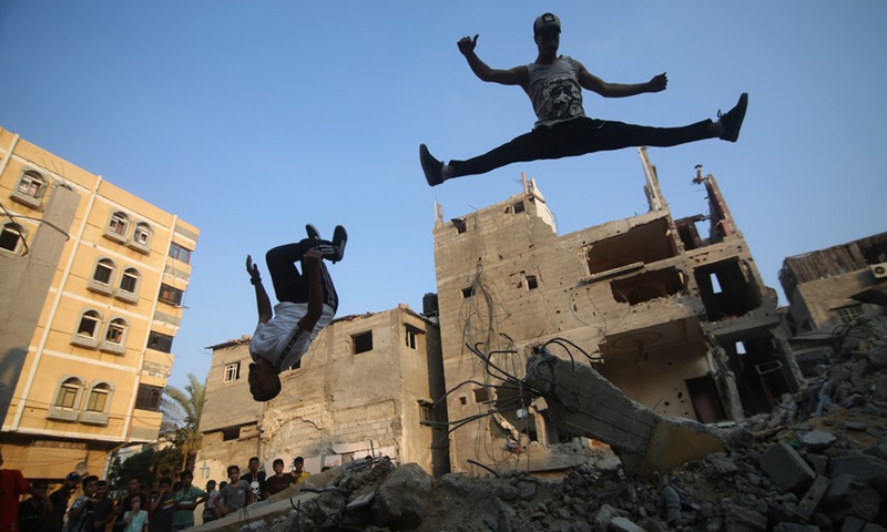 Young people practice parkour over the rubbles of the destroyed houses in the southern Gaza Strip city of Rafah, on Aug. 20, 2022.Photo:Xinhua