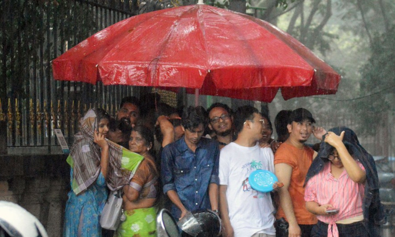 People take shelter from heavy rain in Bangalore, India, Aug. 21, 2022.Photo:Xinhua