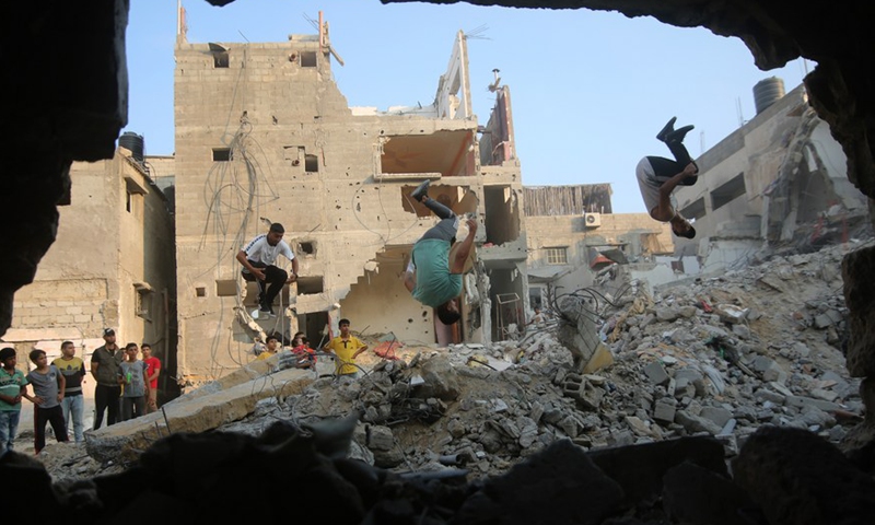 Young people practice parkour over the rubbles of the destroyed houses in the southern Gaza Strip city of Rafah, on Aug. 20, 2022.Photo:Xinhua