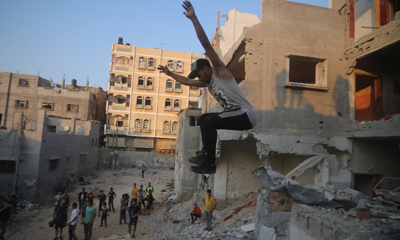 Young people practice parkour over the rubbles of the destroyed houses in the southern Gaza Strip city of Rafah, on Aug. 20, 2022.Photo:Xinhua