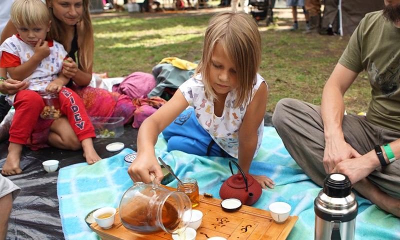 A child pours a cup of mint tea during the Cajomir Fest, an international tea festival, in Prague, the Czech Republic, on Aug. 21, 2022.Photo:Xinhua