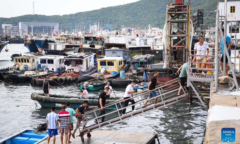 Maritime workers return to a port for shelter in Yangjiang City, south China's Guangdong Province, Aug. 24, 2022. China on Wednesday activated a Level-IV emergency response to possible geological disasters triggered by Typhoon Ma-on, according to the Ministry of Natural Resources.(Photo: Xinhua)