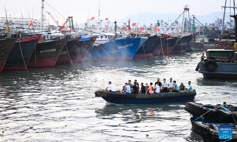 Maritime workers return to a port for shelter in Yangjiang City, south China's Guangdong Province, Aug. 24, 2022. China on Wednesday activated a Level-IV emergency response to possible geological disasters triggered by Typhoon Ma-on, according to the Ministry of Natural Resources.(Photo: Xinhua)