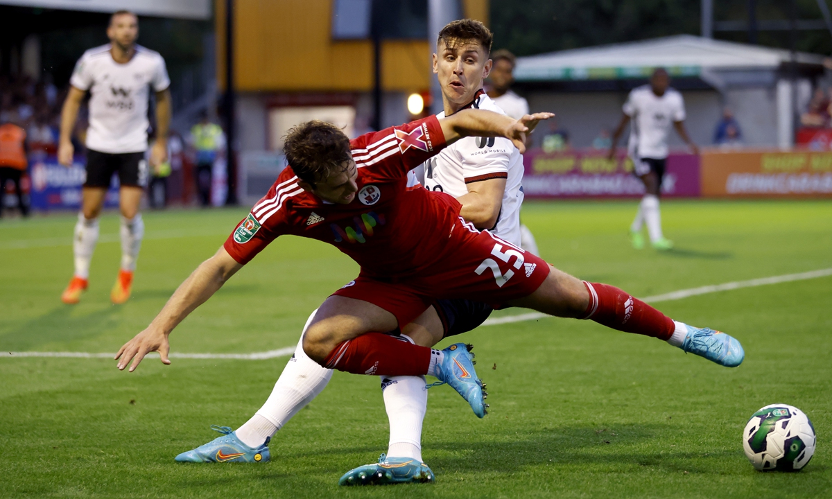 Crawley Town's Nicholas Tsaroulla (left) and Fulham's Tom Cairney battle for the ball during the Carabao Cup second round match at Broadfield Stadium in Crawley, England on August 23, 2022. Photo: VCG