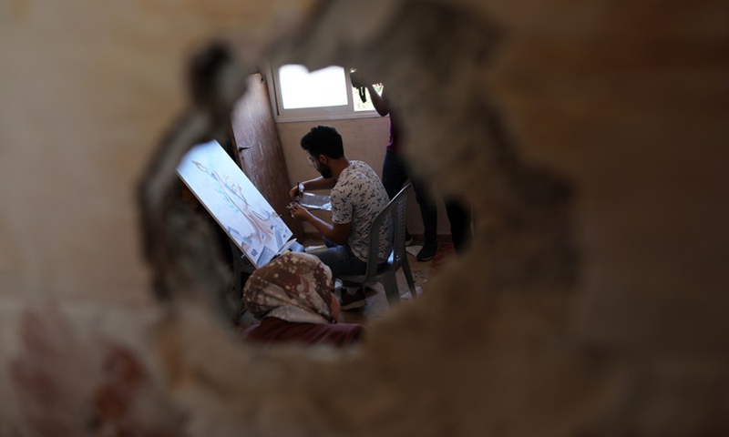 A Palestinian artist is painting at the damaged house of the deceased artist Donyana al-Amour in the southern Gaza Strip city of Khan Younis, on Aug. 23, 2022.(Photo: Xinhua)