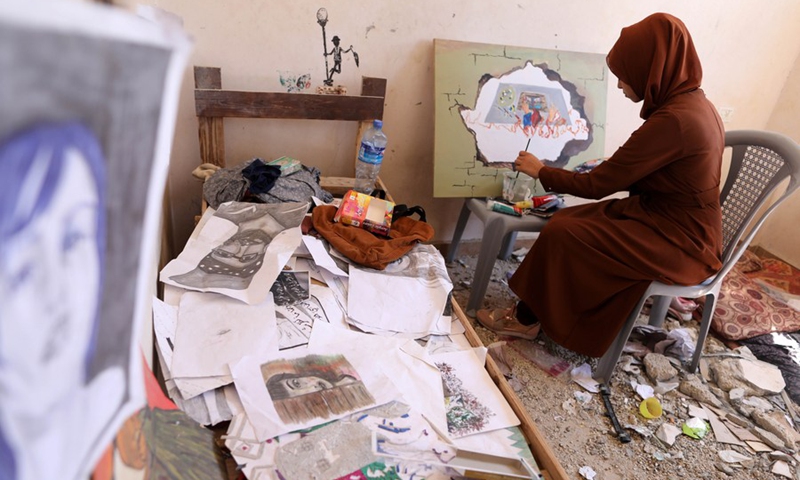 A Palestinian artist is painting at the damaged house of the deceased artist Donyana al-Amour in the southern Gaza Strip city of Khan Younis, on Aug. 23, 2022. (Photo: Xinhua)