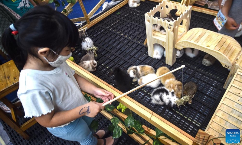 A girl feeds rabbits during the Indonesia International Pet Expo 2022 at Indonesia Convention Exhibition (ICE) in Tangerang, Indonesia, Aug. 27, 2022.Photo:Xinhua