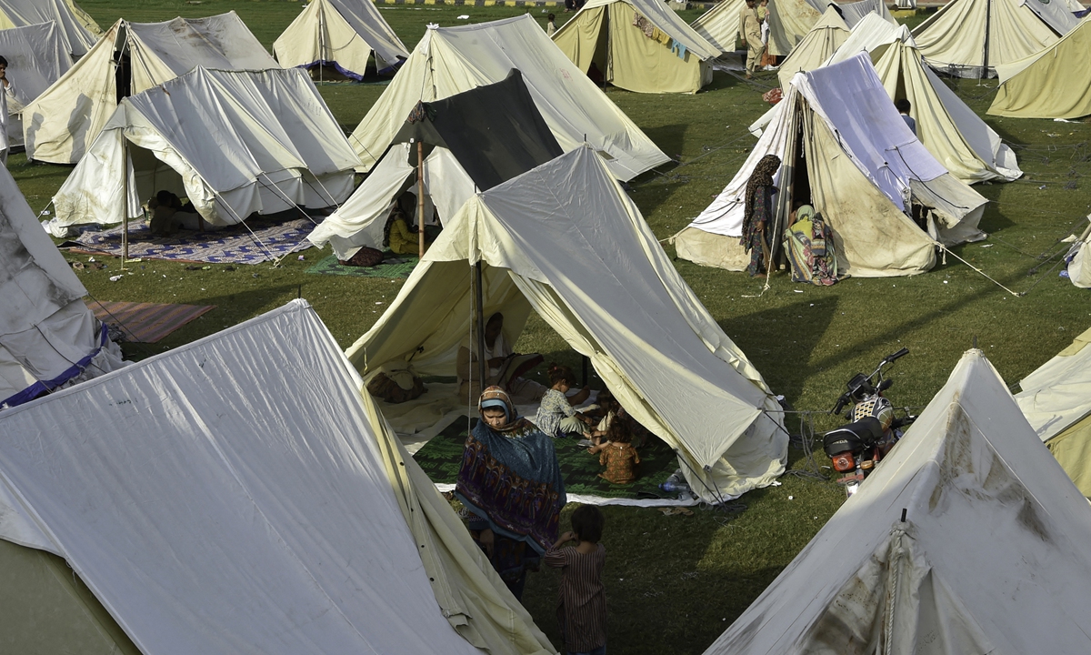 Displaced Pakistanis sit in their tents at a makeshift camp after evacuated from their flood hit homes following heavy monsoon rains in Charsadda district of Khyber Pakhtunkhwa on August 29, 2022. China will provide additional humanitarian aid including 25,000 tents to flood-devastated Pakistan, according to Chinese Foreign Ministry. Photo: AFP