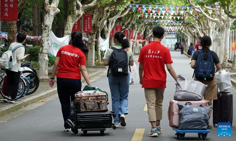 Volunteers help freshmen get to their dormitories at Fudan University in east China's Shanghai, Aug. 28, 2022.Photo:Xinhua