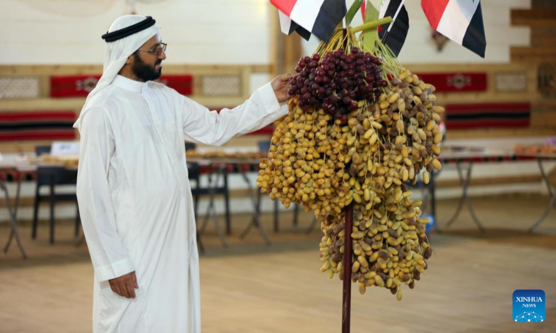 A visitor looks at different types of dates displayed at the sixth annual date festival in Dhuluiya, Iraq, on Sept. 9, 2022. (Xinhua/Khalil Dawood)