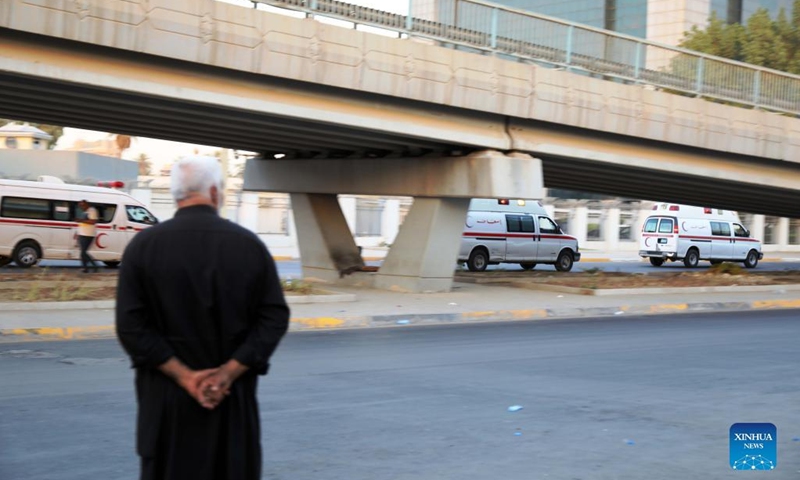 A man watches ambulances transporting injured protesters in Baghdad, Iraq, on Aug. 29, 2022. Thousands of powerful Shiite cleric Moqtada al-Sadr's supporters stormed major Iraqi government buildings in Baghdad, sparking clashes that left at least 12 people killed and dozens wounded late on Monday.(Photo: Xinhua)