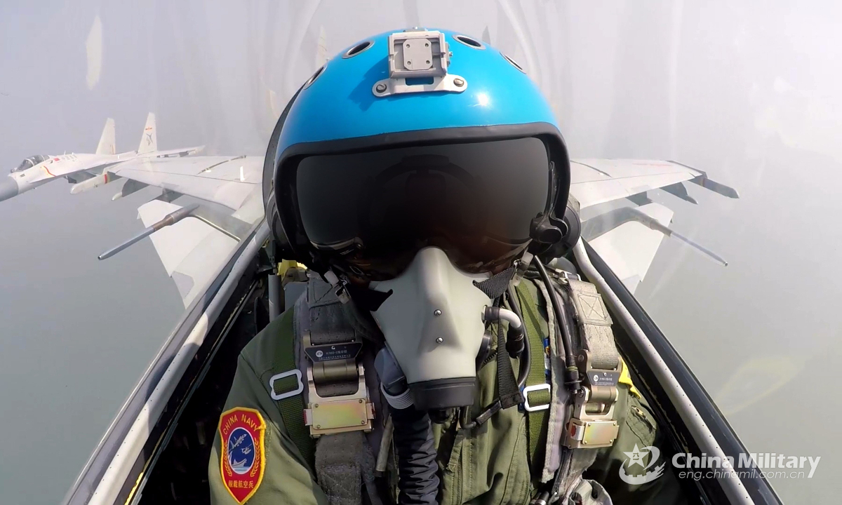 A carrier-based fighter pilot assigned to a naval aviation unit flies his fighter jet in coordination with another jet during a training exercise on July 29, 2022. Photo:China Military