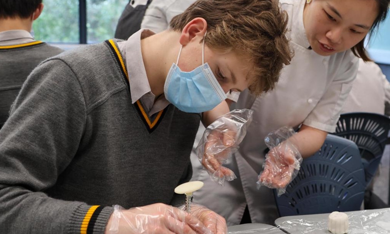 A student makes a moon cake at a Chinese class to celebrate the upcoming Mid-Autumn Festival at a school in Wellington, New Zealand, Sept. 5, 2022. (China Cultural Centre in Wellington/Handout via Xinhua)