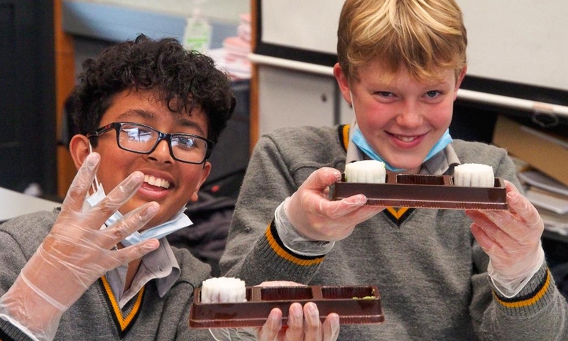 Students show moon cakes they made at a Chinese class to celebrate the upcoming Mid-Autumn Festival at a school in Wellington, New Zealand, Sept. 5, 2022. (China Cultural Centre in Wellington/Handout via Xinhua)