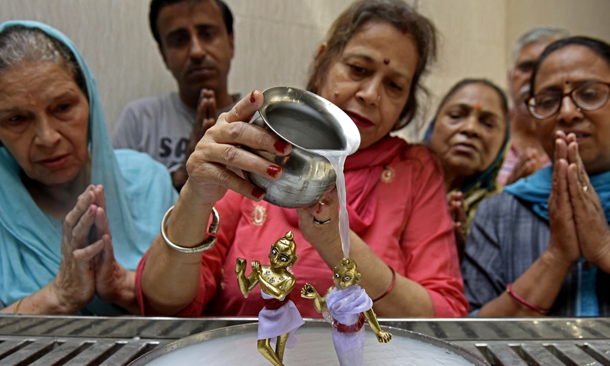 Devotees pour milk and water onto the idols of Hindu deities Radha and Krishna on the occasion of Sri Radha Ashtami which marks the birth of Radha at a temple in Amritsar, India on September 4, 2022. Radha is worshiped as the goddess of love, tenderness, compassion and devotion. She has inspired numerous literary works and her Raslila dance with Krishna has inspired many types of performance arts. Photo: AFP