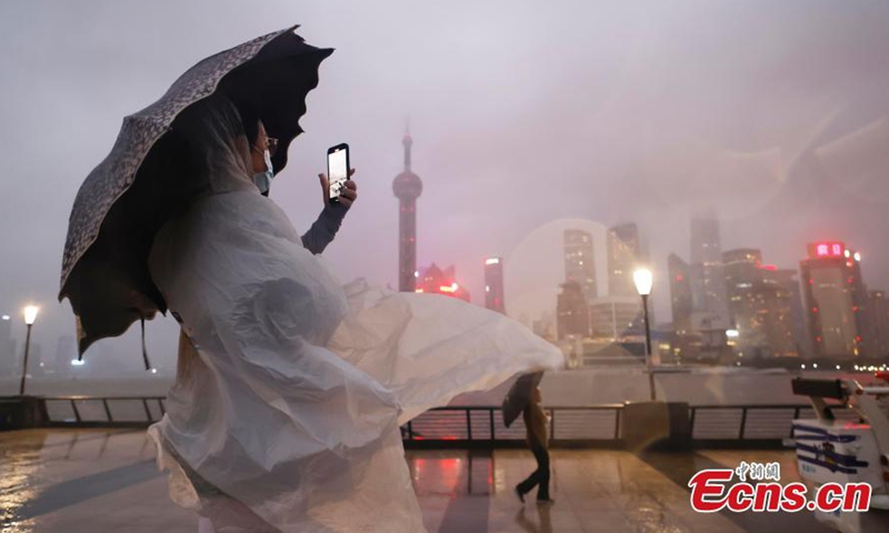 A visitor braves the train to take photos on the Bund in Shanghai, Sept. 4, 2022.Photo:China News Service