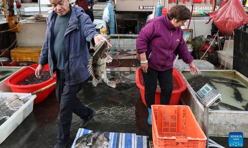 A vendor shows a local fish at Dongji fish market, literally means the easternmost fish market, in Fuyuan City, northeast China's Heilongjiang Province, Sept. 4, 2022.(Photo: Xinhua)