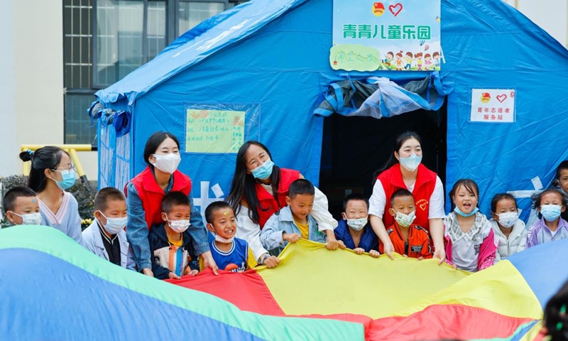 Luo Lian and volunteers play games with kids at the quake relief shelter of Luding No. 2 high school in Luding County, southwest China's Sichuan Province, Sept. 10, 2022.Photo:Xinhua