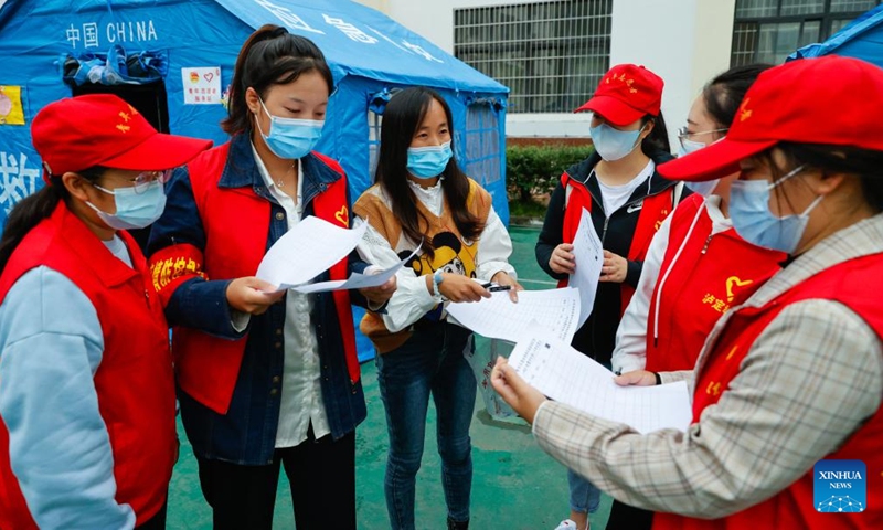 Luo Lian (3rd L) discusses with other volunteers about their tutoring plans at the quake relief shelter of Luding No. 2 high school in Luding County, southwest China's Sichuan Province, Sept. 10, 2022.Photo:Xinhua