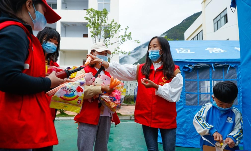 Luo Lian (2nd R) and her 4-year-old son prepare toys and balloons for the kids at the quake relief shelter of Luding No. 2 high school in Luding, southwest China's Sichuan Province, Sept. 10, 2022.Photo:Xinhua