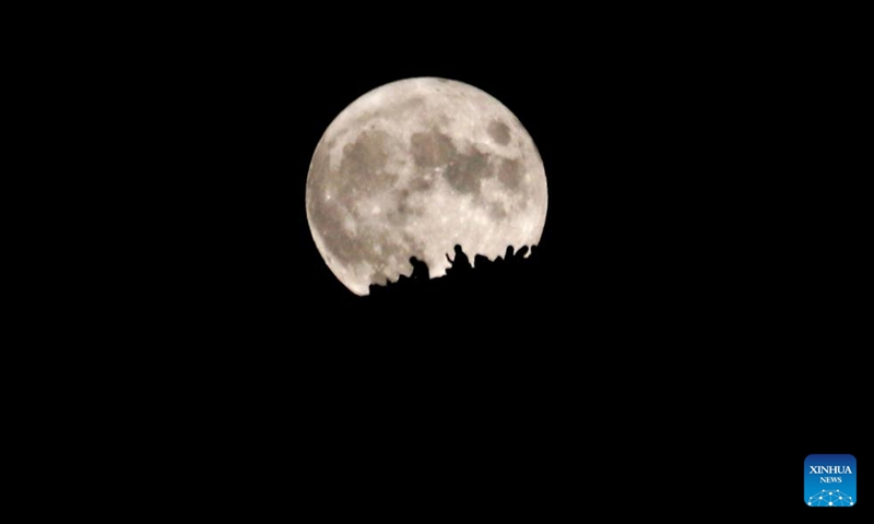 Tourists watch the full moon at the Mingsha Mountain scenic area in Dunhuang, northwest China's Gansu Province, Sept. 10, 2022.Photo:Xinhua