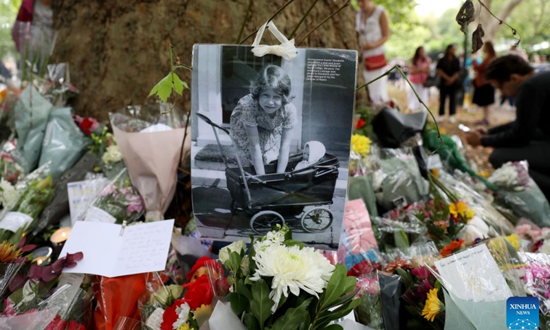 A photo is seen amid flowers commemorating the late Queen Elizabeth II at Green Park in London, Britain, Sept. 10, 2022.Photo:Xinhua