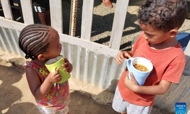 Children hold cups with food served at Needy Hearts Soup Kitchen in Hakahana, an informal settlement in Windhoek, Namibia, on Sept. 12, 2022.Photo:Xinhua