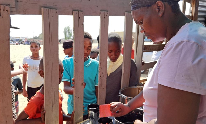 Maria Savage (R), a founder of Needy Hearts Soup Kitchen, serves food to children in Hakahana, an informal settlement in Windhoek, Namibia, on Sept. 12, 2022.Photo:Xinhua