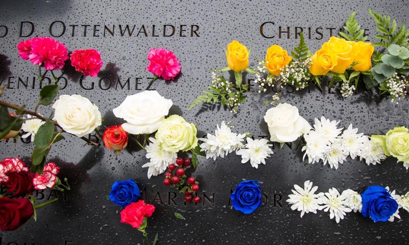 Flowers are placed on a plate inscribed with the names of 9/11 victims at the National September 11 Memorial and Museum in New York, the United States, on Sept. 11, 2022.Photo:Xinhua