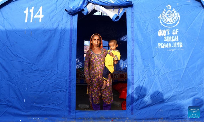 A flood-affected woman with her child is seen at a makeshift tent on the outskirts of Hyderabad, Pakistan, Sept. 18, 2022.Photo:Xinhua