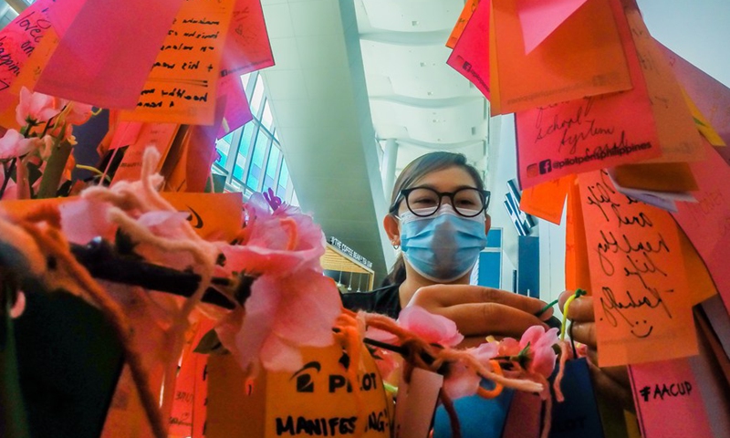 A woman writes a note at the wishing tree at the Manila International Book Fair in Pasay City, the Philippines, Sept. 18, 2022.Photo:Xinhua