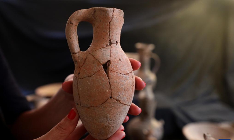 An archeologist shows a pottery vessel in which opium remains were found, in Jerusalem, on Sept. 20, 2022.(Photo: Xinhua)