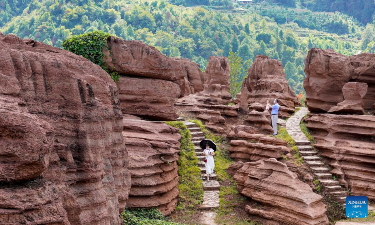 Tourists visit a red stone forest geopark in Youyang Tujia and Miao Autonomous County, southwest China's Chongqing Municipality, Oct. 3, 2022. The Youyang red stone forest geopark, which has the karst landform, opened to the public during the National Day holiday. Photo:Xinhua