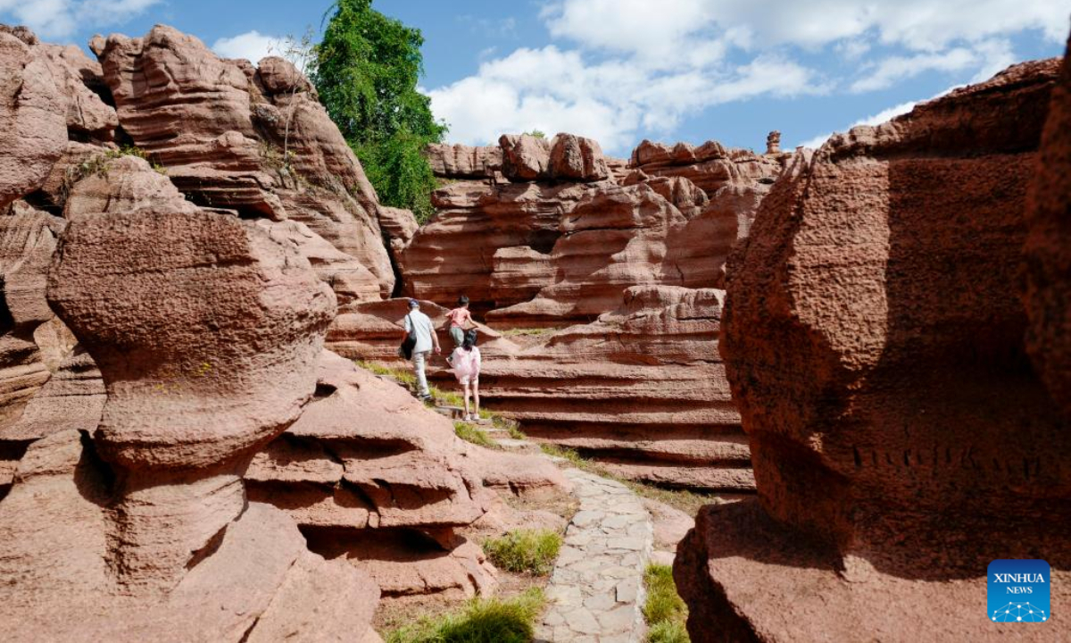 Tourists visit a red stone forest geopark in Youyang Tujia and Miao Autonomous County, southwest China's Chongqing Municipality, Oct. 3, 2022. The Youyang red stone forest geopark, which has the karst landform, opened to the public during the National Day holiday. Photo:Xinhua