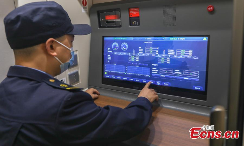 A technician inspects a Fuxing bullet train at a maintenance station of Nanchang Railway in Nanchang, east China's Jiangxi Province, Oct. 8, 2022. (Photo: China News Service/Liu Lixin)