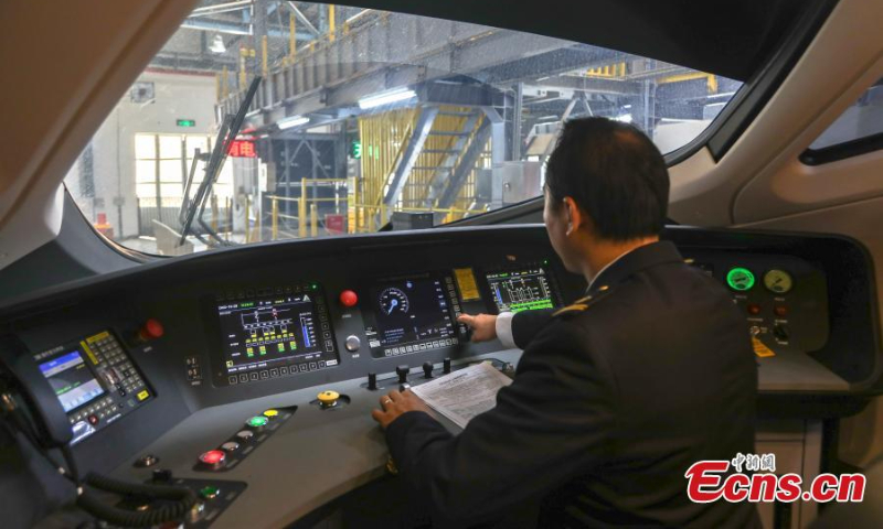 A driver checks signal signs on a new Fuxing bullet train at a maintenance station of Nanchang Railway in Nanchang, east China's Jiangxi Province, Oct. 8, 2022. (Photo: China News Service/Liu Lixin)