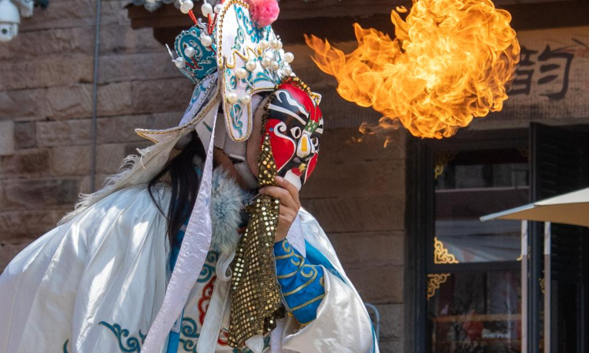 An artist performs Chuanju (Sichuan opera) in Ciqikou ancient town, southwest China's Chongqing Municipality, Oct. 2, 2022. During the National Day holiday, the scenic area Ciqikou has conducted various activities themed with traditional Chinese culture to attract tourists. (Xinhua/Tang Yi)