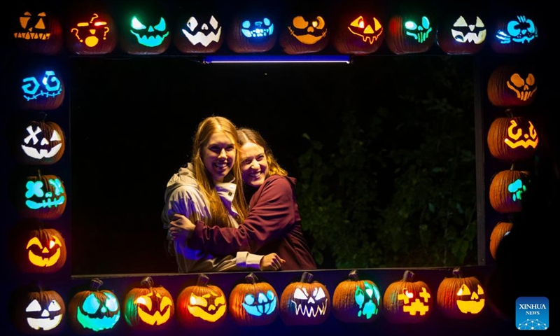 People pose for photos with handcrafted pumpkins during the 2022 Pumpkins After Dark event in Milton, Ontario, Canada, on Sept. 23, 2022.Photo:xinhua