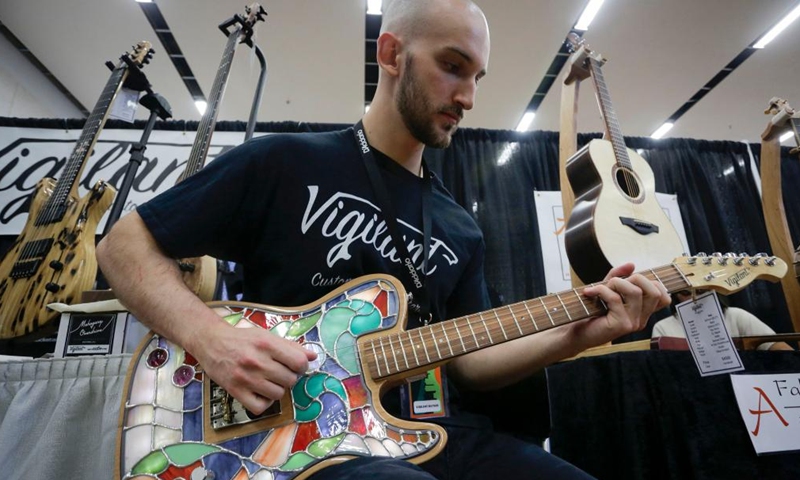 A musician tries a handmade guitar at the Vancouver International Guitar Festival in Vancouver, Canada, on Sept. 24, 2022.Photo:Xinhua