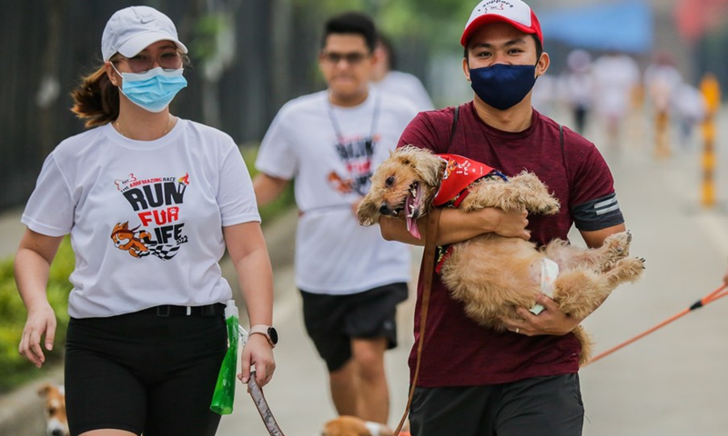 A man carries his pet dog during the Run Fur Life marathon in Pasig City, the Philippines, Sept. 25, 2022.(Photo: Xinhua)