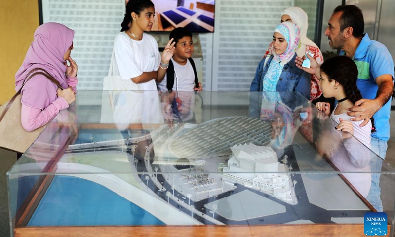 Visitors look at a model of Bibliotheca Alexandrina in Alexandria, Egypt, on Sept. 27, 2022. Bibliotheca Alexandrina, a massive unique library and cultural symbol of the Egyptian Mediterranean coastal city of Alexandria which was founded by King Alexander the Great some 2,300 years ago, features a disc-shaped exterior and 11 internal levels, all under one glistening, tilting roof.(Photo: Xinhua)