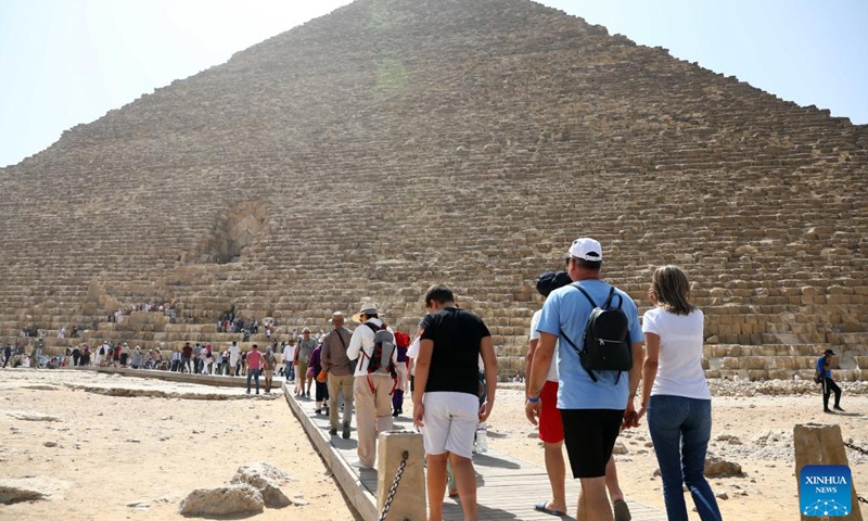 Tourists visit the Giza Pyramids scenic spot during the World Tourism Day in Giza, Egypt, Sept. 27, 2022. Egypt on Tuesday opened most of its museums and archaeological sites, including the Giza Pyramids, to visitors for free on the occasion of the World Tourism Day.(Photo: Xinhua)