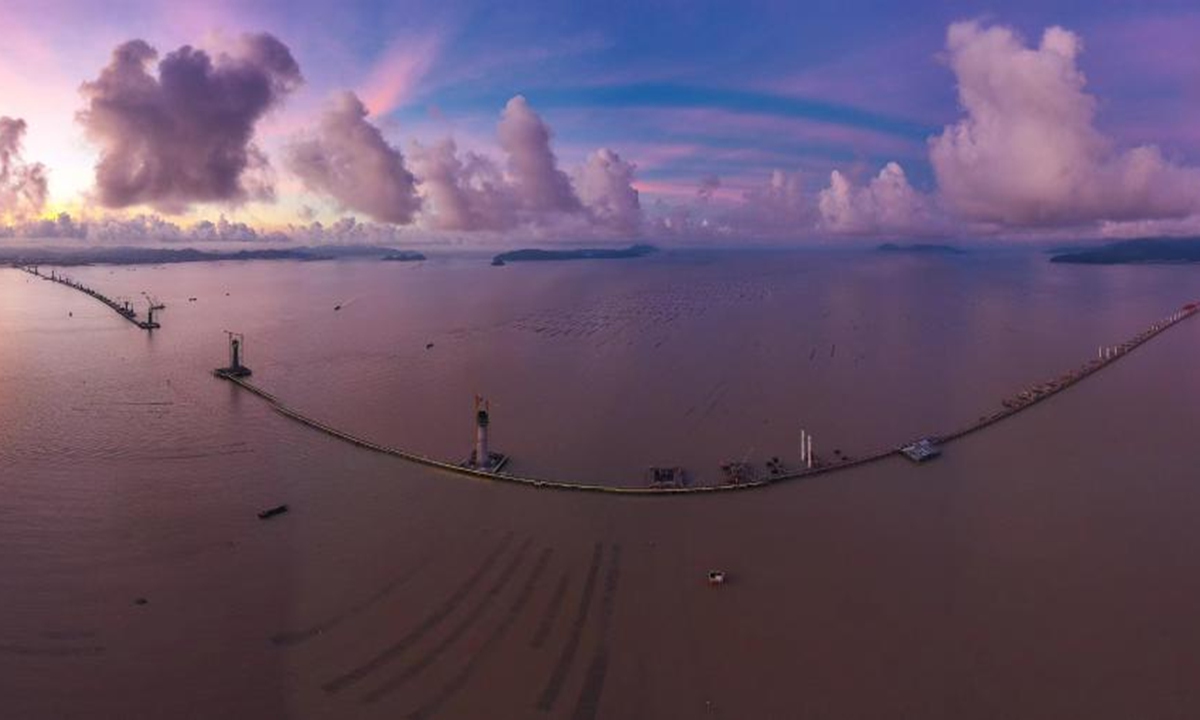 Aerial photo taken on June 28, 2022 shows the Huangmao Sea Channel Bridge which is under construction in south China's Guangdong Province. The Huangmao Sea Channel Bridge, which stretches across the Huangmao Sea water area near the Yamen outlet of Pearl River Estuary, is expected to be finished in 2024. (Xinhua/Liu Dawei)