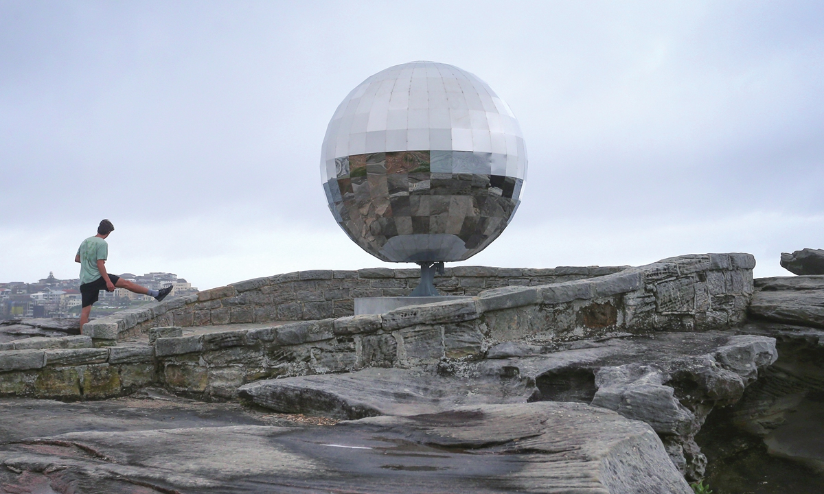 A runner stretches for a moment near the Sculpture by the Sea, Bondi exhibition in Sydney, Australia. Photo: VCG