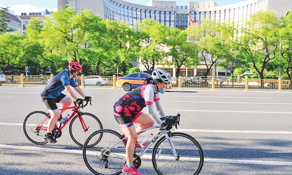 Cyclists ride down the streets of Beijing. Photo: VCG