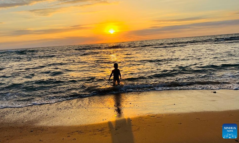 A boy enjoys the sunset over the Mediterranean Sea in Tel Aviv, Israel, on Oct. 7, 2022.(Photo: Xinhua)